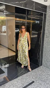 Vestido largo estampado con escote en V profundo y tirantes anchos. El diseño presenta un frunce o nudo en el centro del busto y tajos laterales en la falda.