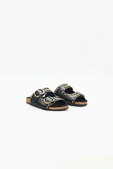 Sandalias negras de cuero con tachas metálicas y hebillas doradas. La plantilla es de corcho y la suela de goma eva.