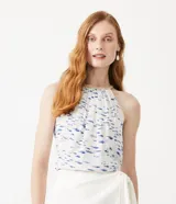 Musculosa blanca con estampado de peces azules, cuello halter con detalle de cuerda y sisa americana.