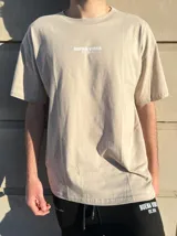 Remera negra de corte semi oversize con estampado frontal con la frase "Buena Vibra Est. 2022" en letras blancas.