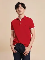 Chomba Tommy Hilfiger color rojo de corte slim, con cuello polo, cartera de dos botones, mangas cortas con ribete blanco y logo de la marca bordado en el pecho.