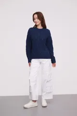 Sweater de punto color mostaza, con diseño de trenzas y puños acampanados.