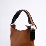 Cartera tipo tote color marrón con paneles laterales con estampado de piel de serpiente.