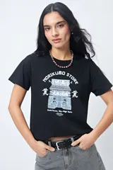 Remera negra de algodón con estampado blanco de un edificio de estilo oriental y texto en inglés y japonés.