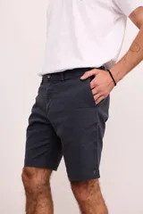 Bermuda de gabardina color verde oliva, con bolsillos laterales y traseros. Cierre frontal con botón y cremallera.