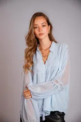 Camisa blanca de plumetí con cuello mao, mangas largas abullonadas con puños elásticos y cordón con borlas en el escote.