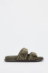 Sandalias planas color verde militar con doble tira con hebillas y tachas metálicas.