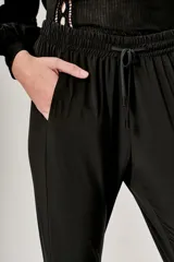 Pantalón negro de corte cropped con cintura elastizada ajustable con cordón.