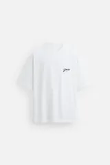 Camiseta blanca de corte relaxed fit, cuello redondo y manga corta. Estampado con textura combinada a contraste en la espalda.