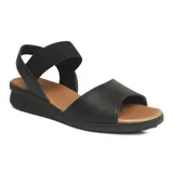 Sandalia casual de cuero color negro con suela color caramelo. Cuenta con una tira ancha de cuero con perforaciones en la parte delantera y una tira elástica en el tobillo para mayor ajuste.