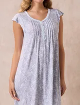 Camisón corto negro con estampado de lunares blancos, escote en V con puntilla blanca y botones.