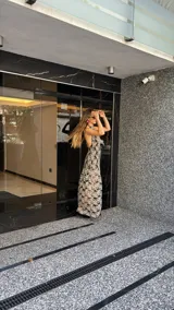 Vestido midi de encaje floral color beige sobre base negra, con cuello halter y falda con vuelo.