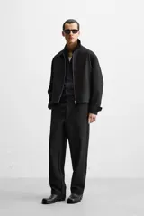 Pantalón negro de corte regular, confeccionado en tejido con viscosa, con cintura elástica, bolsillos frontales y trasero de vivo.