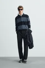 Polo relaxed fit de punto tejido en hilatura de algodón, a rayas horizontales en tonos azul y negro. Cuello solapa con cierre frontal de botonadura, manga larga y acabados en rib.