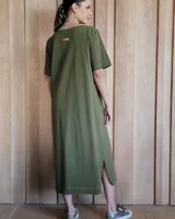 Vestido midi negro con cuello redondo y mangas cortas. Presenta dos bolsillos cuadrados en el pecho y ribetes blancos en cuello, mangas, bolsillos y ruedo.