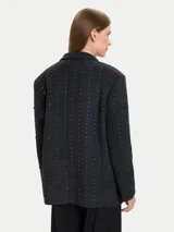 Blazer de mezcla de lana color gris oscuro, con apliques tipo joya en forma de puntos dispuestos en líneas verticales. Presenta solapas de muesca, cierre frontal de un solo botón y bolsillos de parche delanteros.