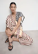 Mono largo de satén con estampado de rayas marrones y blancas, cuello en V, mangas cortas, lazo en la cintura y cierre de cremallera en la espalda.