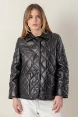 Campera corta negra de cuero ovino italiano, con cuello camisero, cierre frontal con broches a presión y bolsillos laterales. Diseño capitoneado en forma de rombos.