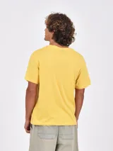 Remera de manga corta color mostaza con cuello redondo y estampado frontal en blanco que dice "NEW YORK PRO TENNIS CLASSIC september 15-23, 1994".