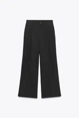 Pantalón negro de tiro alto con cintura con trabillas, bolsillos laterales y de vivo en espalda, pernera recta y cierre frontal con cremallera y botón. Confeccionado en hilatura con modal.