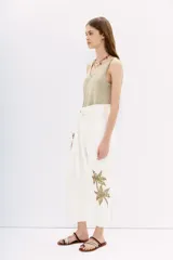 Pantalón blanco de tiro alto con corte paper bag, cintura con lazo a tono y bordado de lentejuelas y piedras en el lateral.