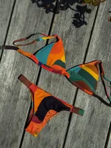 Conjunto de bikini turquesa con corpiño triangular de corte fijo, breteles regulables y almohadillas desmontables, y bombacha vedetina con frunce elástico en los costados.