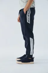 Pantalón de jogging gris oscuro de felpa con puños, cintura ajustable con cordón y logo estampado en la pierna.