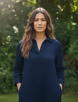 Vestido azul marino de algodón con cuello solapa y escote en V. Manga 3/4 regulable con presilla y botón. Bolsillos verticales laterales. Abertura central con botones en la espalda.