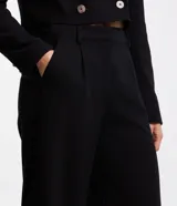 Pantalón de vestir negro de corte recto, con bolsillos laterales y traseros. Se ajusta a la cintura con cierre de botón y cremallera.
