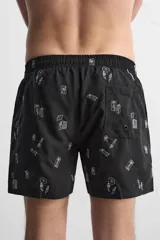 Bañador negro con estampado de dibujos en blanco. Tiene cintura elástica ajustable con cordón, bolsillos laterales y trasero.