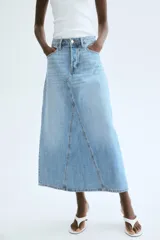 Pollera midi de denim celeste, de corte evasé, con tiro alto, cinco bolsillos y cierre frontal con botones.