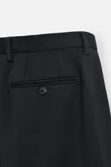 Pantalón de vestir negro de lana, corte recto, con bolsillos laterales y traseros de ojal con botón.