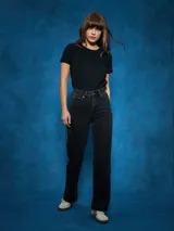 Jean de tiro alto, color negro, con corte recto y detalle de abertura con cierre en el bajo de la pierna.