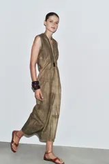 Vestido midi de Zara Woman Collection, confeccionado en mezcla de ramio con efecto tie-dye en tonos tierra. Presenta escote pico, sisa y pliegues laterales. Cierre trasero con cremallera oculta.