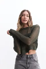 Sweater de punto calado color verde militar con sutiles brillos, escote redondo y corte crop.