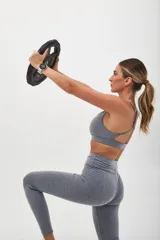 Top deportivo color beige con banda inferior azul y tirantes finos azul marino. Espalda cruzada con doble tira.