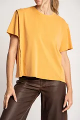 Remera color mostaza de algodón con mangas cortas y corte recto. Presenta costuras a la vista en hombros y laterales.