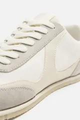 Zapatilla deportiva monocolor negra con cordones, capellada de cuero y suela ultrafina.