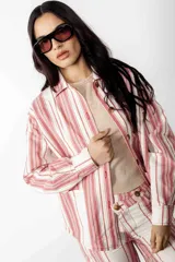 Sobrecamisa a rayas verticales rojas y blancas, de corte recto, con cuello camisero, cierre frontal con botones, mangas largas con puños abotonados y bolsillos de parche en el pecho.