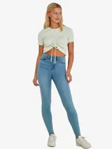 Pantalón de jean celeste, de corte skinny, tiro alto y largo hasta el tobillo.