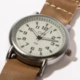 Reloj de pulsera con correa símil cuero negra y esfera blanca con números arábigos.