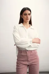 Camisa blanca de mangas largas con detalles bordados y cuello clásico.