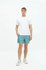 Short de baño turquesa con estampado abstracto en blanco, cintura elástica con cordón ajustable, dos bolsillos laterales y uno trasero.