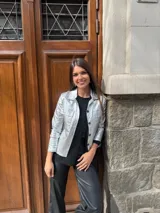 Chaqueta plateada metalizada con cuello camisero, cierre frontal con botones, bolsillos de parche en el pecho y corte recto.
