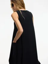 Vestido midi negro de silueta balloon con bolsillos laterales y mezcla de texturas en laterales y frente.