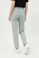 Pantalón de jean azul oscuro, tiro alto, de corte recto y largo hasta el tobillo.