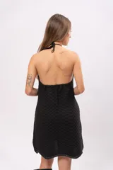 Vestido corto negro de algodón con cuello halter y espalda descubierta.