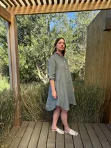 Vestido camisero blanco de lino, con cuello camisero, manga larga con botón para recoger, cierre frontal con botones de nácar, bolsillo en el pecho y diseño asimétrico más largo en la parte trasera.