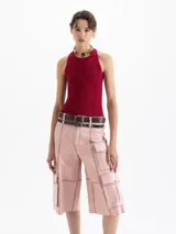 Top de punto acanalado color negro, ajustado al cuerpo y de largo por encima de la cadera. Presenta cuello redondo cerrado y breteles cruzados en la espalda. Confeccionado en hilado frío.