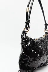 Cartera baguette negra cubierta de lentejuelas, con asa corta de cuero sintético.